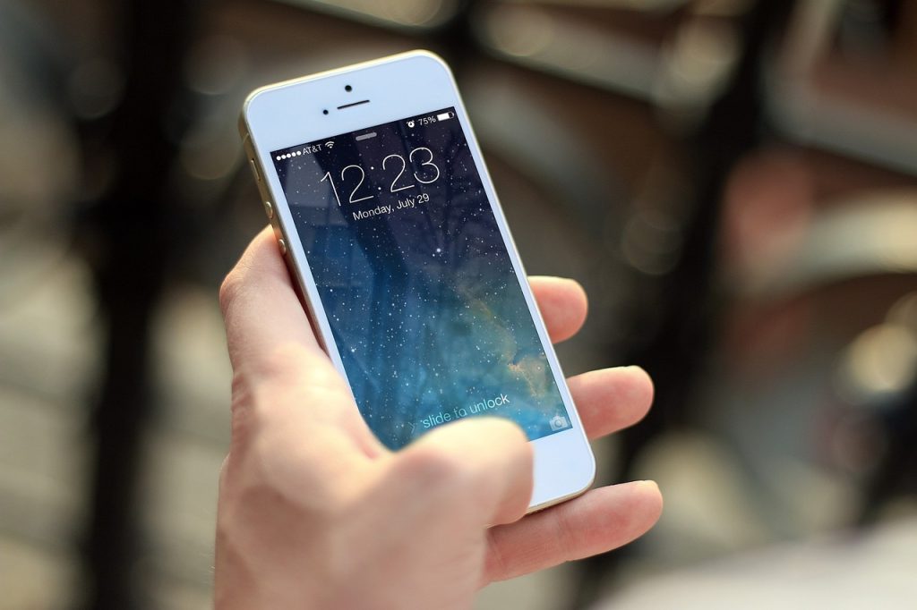 Ręka trzymająca telefon z ekranem blokady.