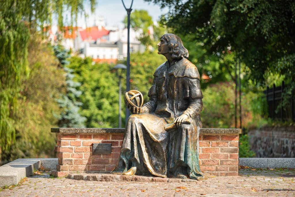 Pomnik siedzącego uczonego w parku.