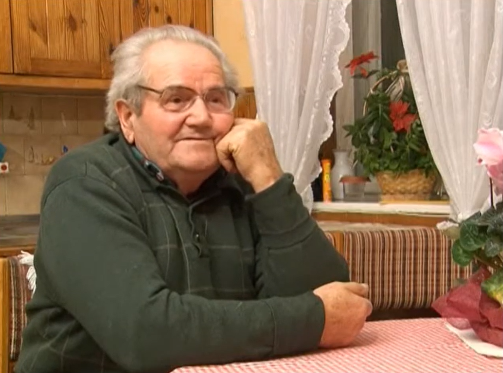 Mężczyzna siedzący przy stole w kuchni.