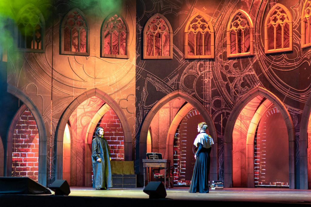 Scena teatralna z dwiema postaciami w kostiumach.