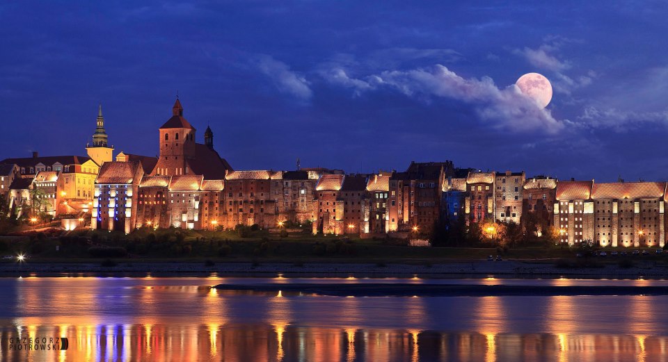 Widok oświetlonej architektury nad rzeką nocą