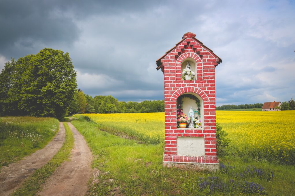 Czerwony kapliczka przy drodze w polu