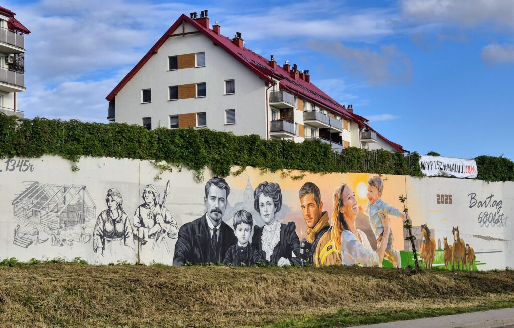 Mural przedstawiający postacie historyczne i rodzinne, z domem w tle.