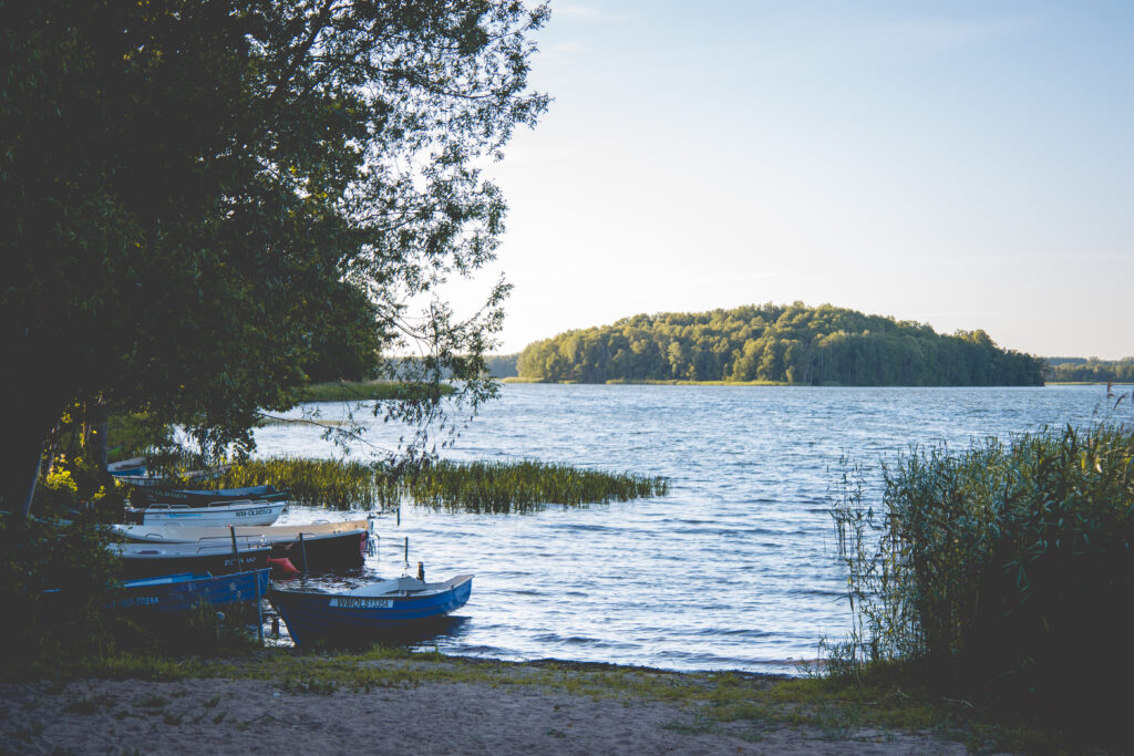 Widok na jezioro z łódkami w porze wieczornej.