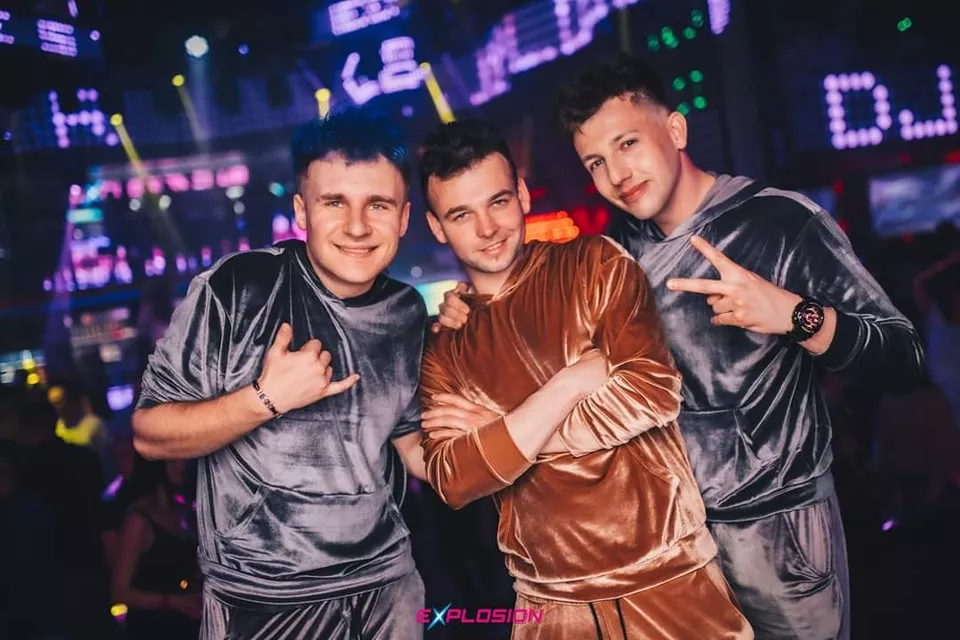 Trzech mężczyzn w modnych ubraniach w klubie.