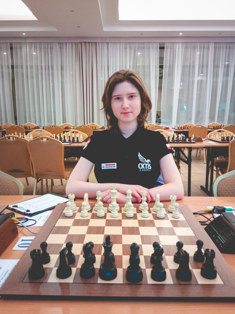 Uczestniczka turnieju szachowego z planszą.