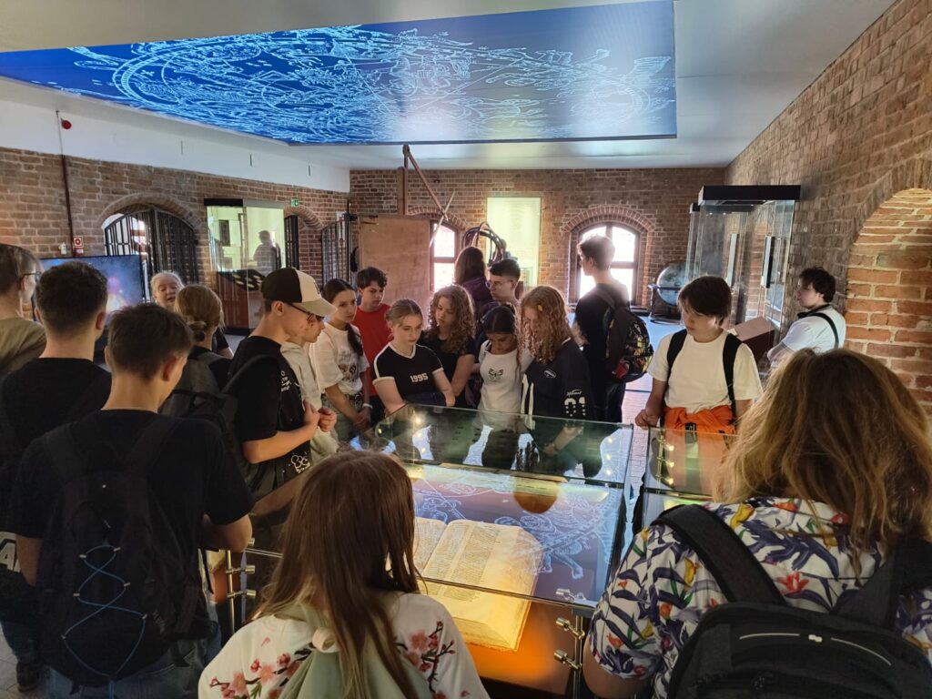 Grupa uczniów oglądająca eksponaty w muzeum.