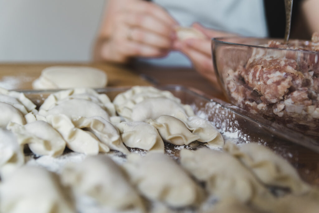 Osoba lepione pierogi z mięsem