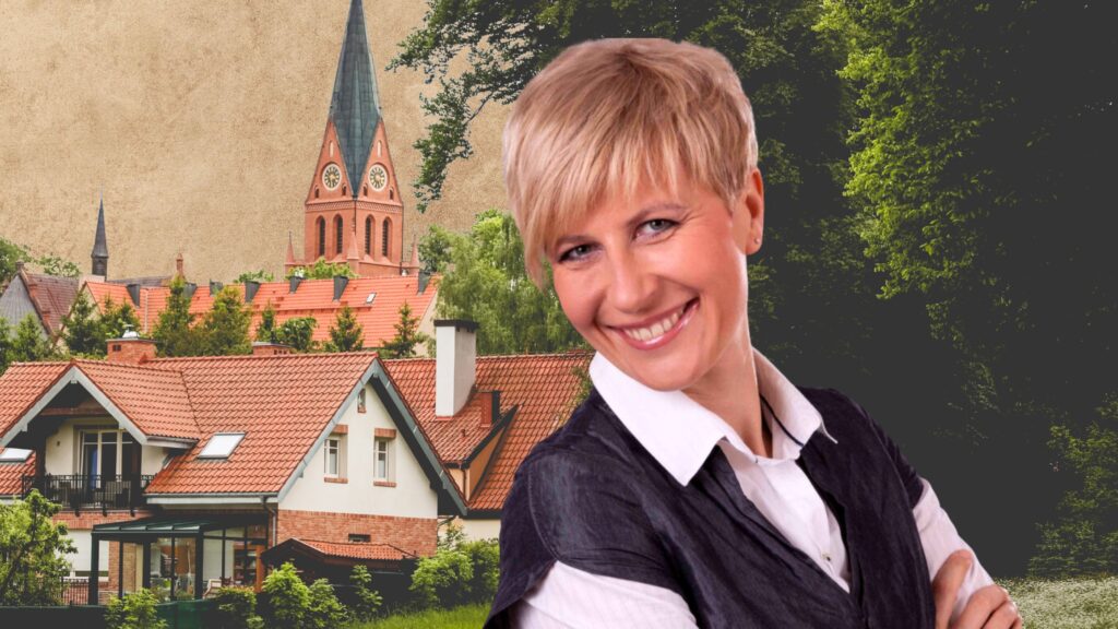 Kobieta uśmiechająca się na tle domów i kościoła.