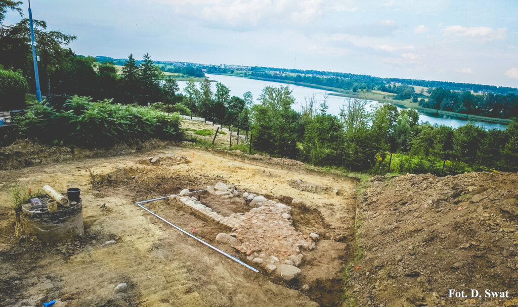 Widok na teren wykopalisk z rzeką w tle.