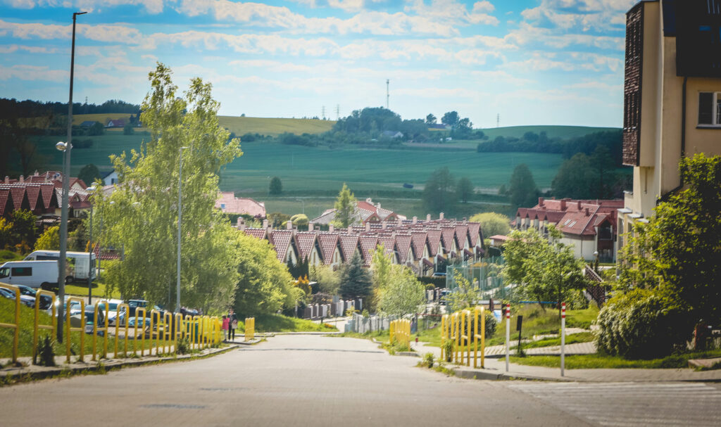 Widok na osiedle domów jednorodzinnych w zielonej okolicy.