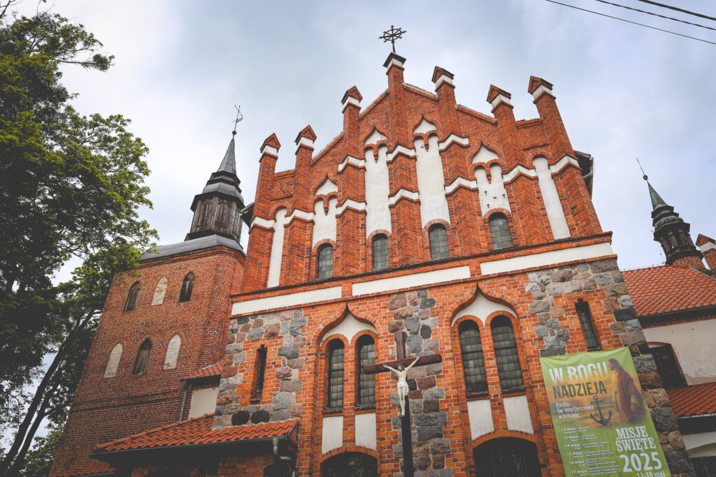 Widok na czerwoną, gotycką świątynię z elementami kamiennymi.