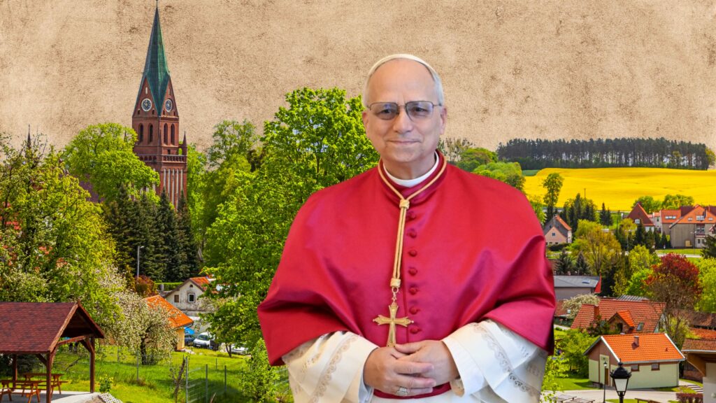 Mężczyzna w czerwonym płaszczu stojący z tłem wież kościelnych i krajobrazu.