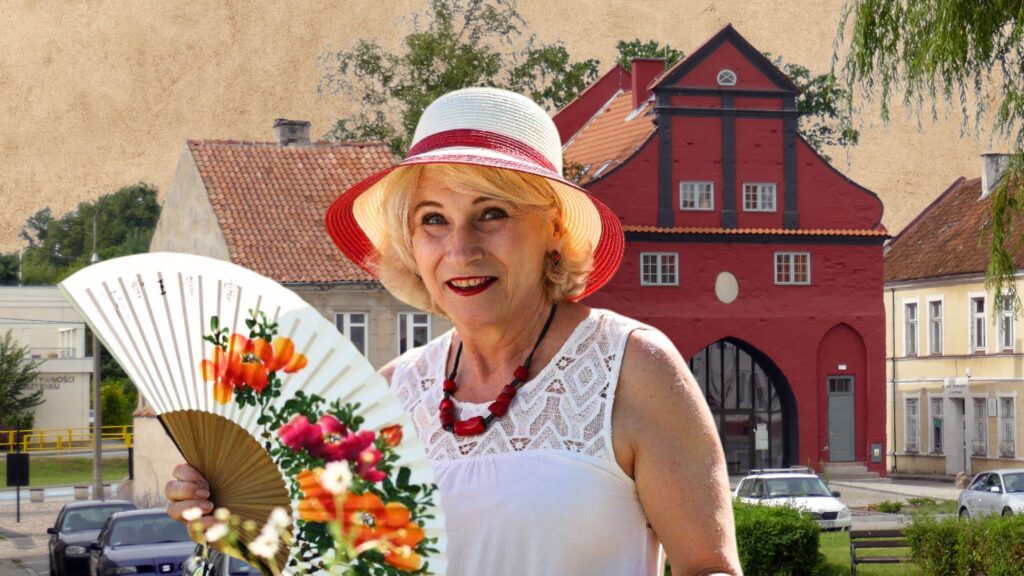 Kobieta z wachlarzem przed kolorową architekturą.