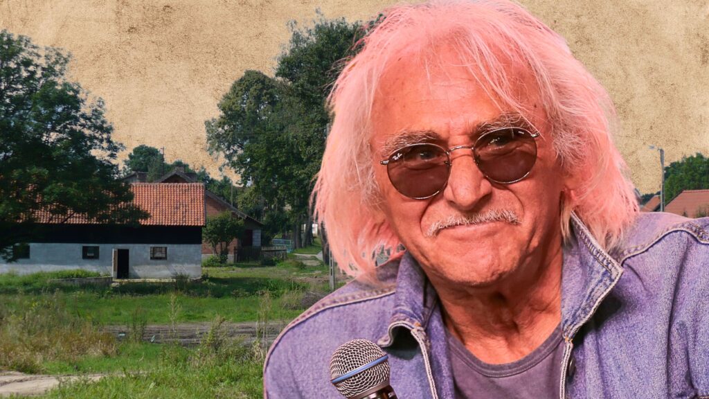 Mężczyzna z jasnoróżowymi włosami w okularach przeciwsłonecznych.
