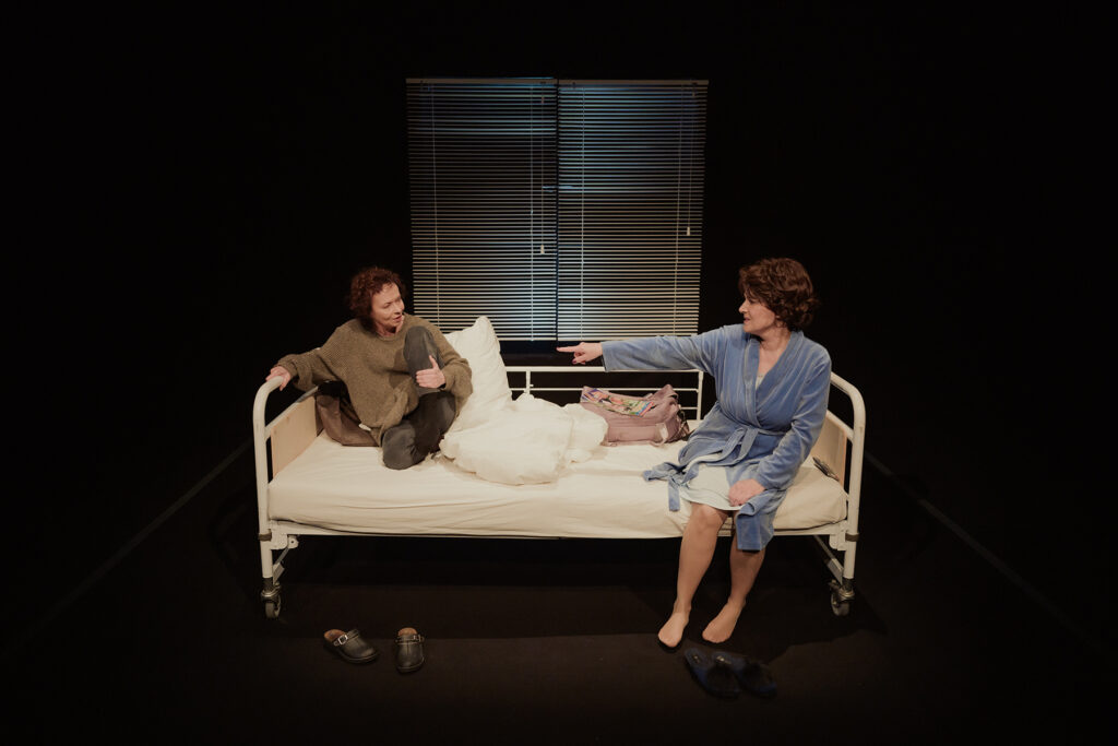 Dwie osoby na łóżku w teatrze.