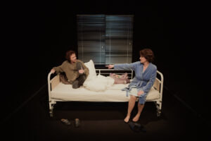 Dwie osoby na łóżku w teatrze.