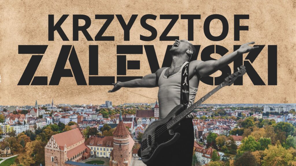 Muzyk z gitarą basową na tle miasta.