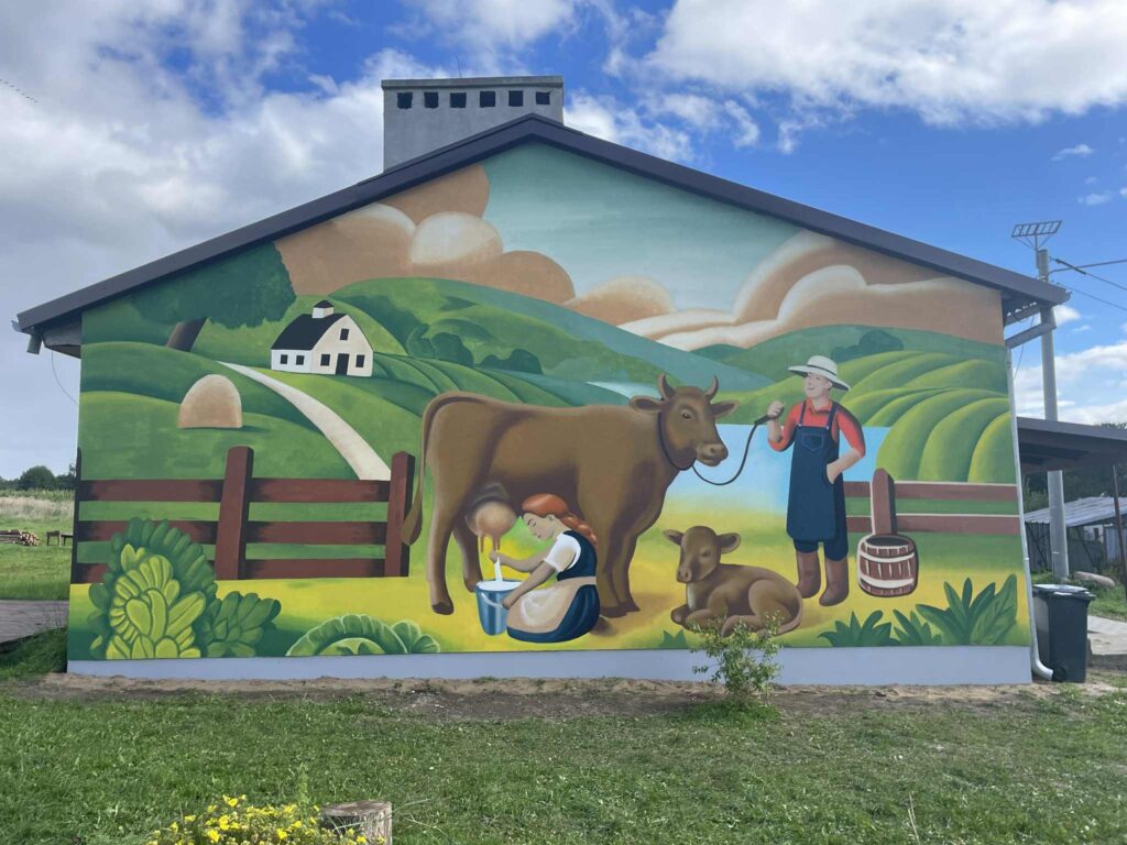 Murals depicting a farmer, cow, and landscape.