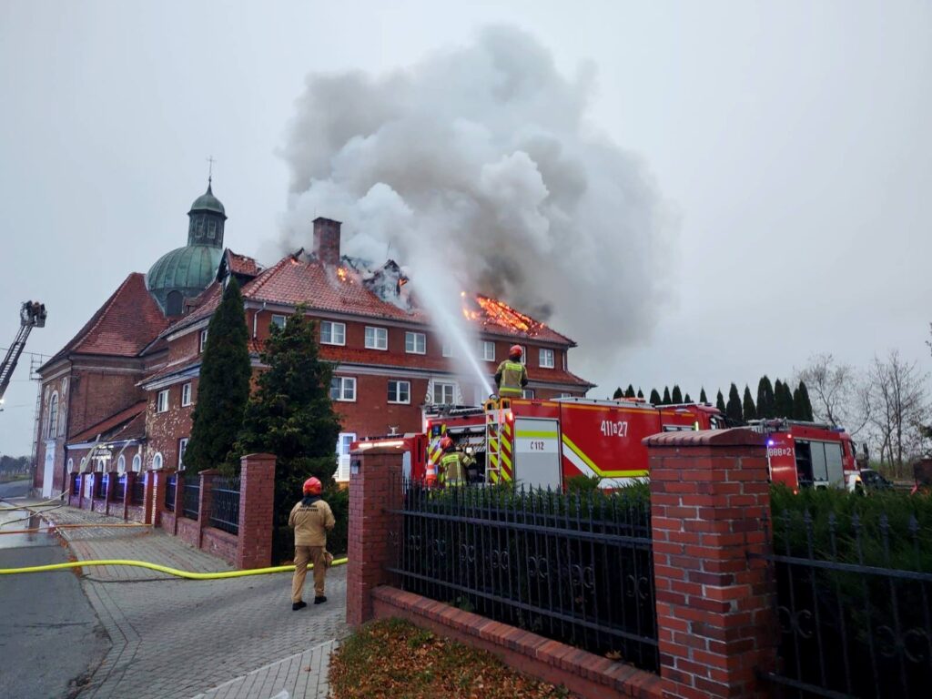 W budynku strażacy gaszą pożar.