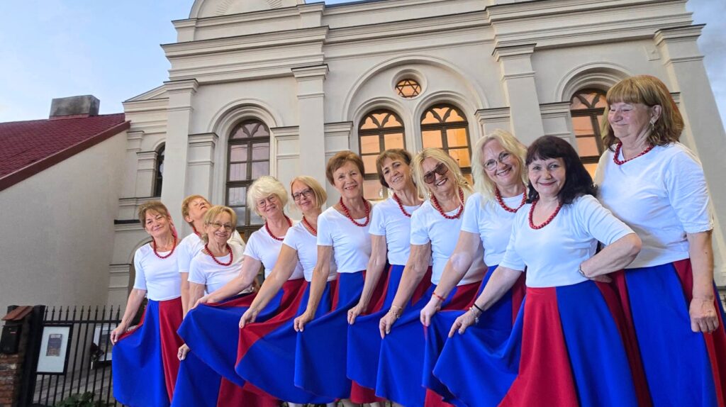 Grupa kobiet w kolorowych strojach ludowych.