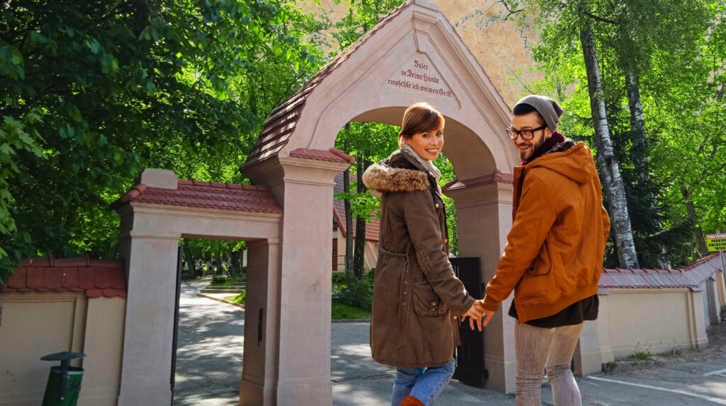 Para trzymająca się za ręce przy wejściu do parku.