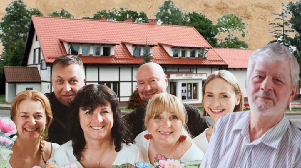 Grupa ludzi z uśmiechami przed budynkiem.