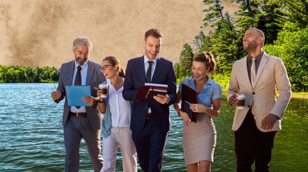 Grupa pięciu osób idzie wzdłuż jeziora, uśmiechając się.