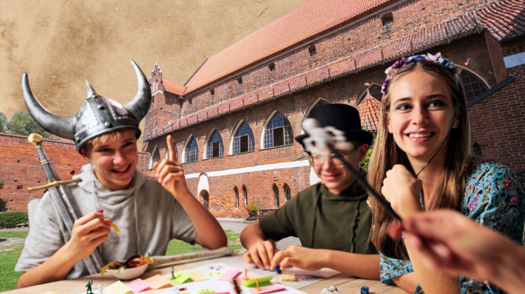 Grupa dzieci bawi się przy stole, w tle zamek.