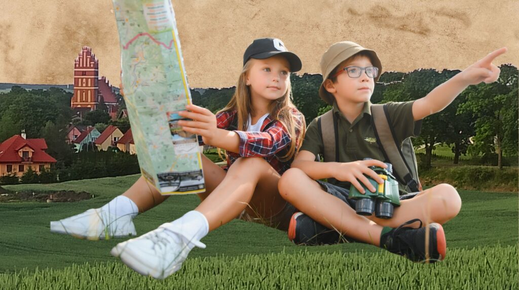 Dwoje dzieci siedzi na trawie, jedno trzyma mapę, drugie wygląda w stronę horyzontu.