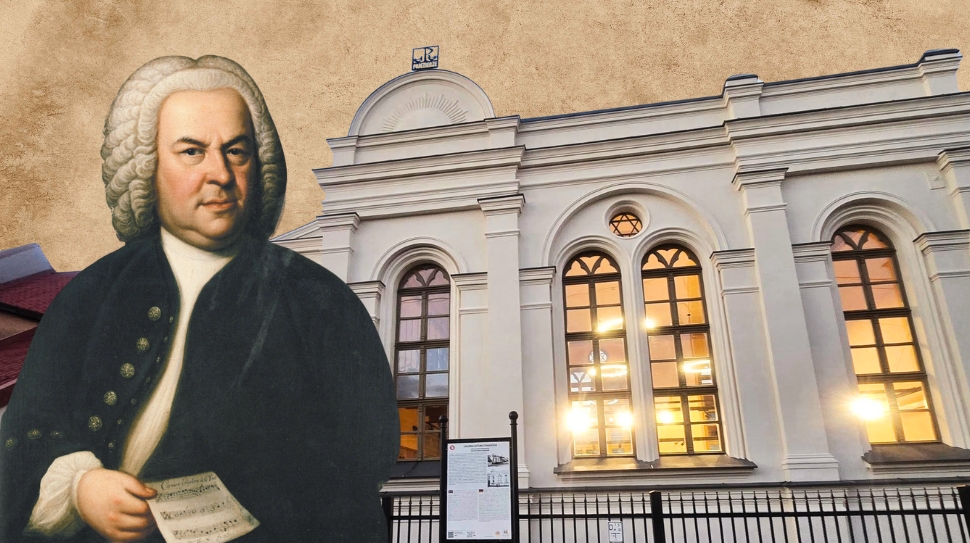 Portret mężczyzny z kartką w ręku przed budynkiem.
