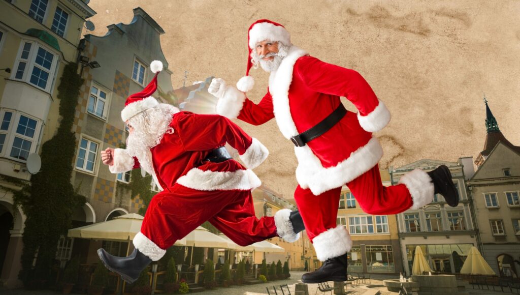 Dwaj Mikołaje biegają na tle architektury.