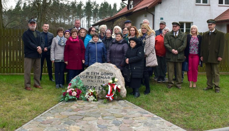 Grupa ludzi przed pomnikiem upamiętniającym nauczycieli zmarłych w latach 1934-1939.