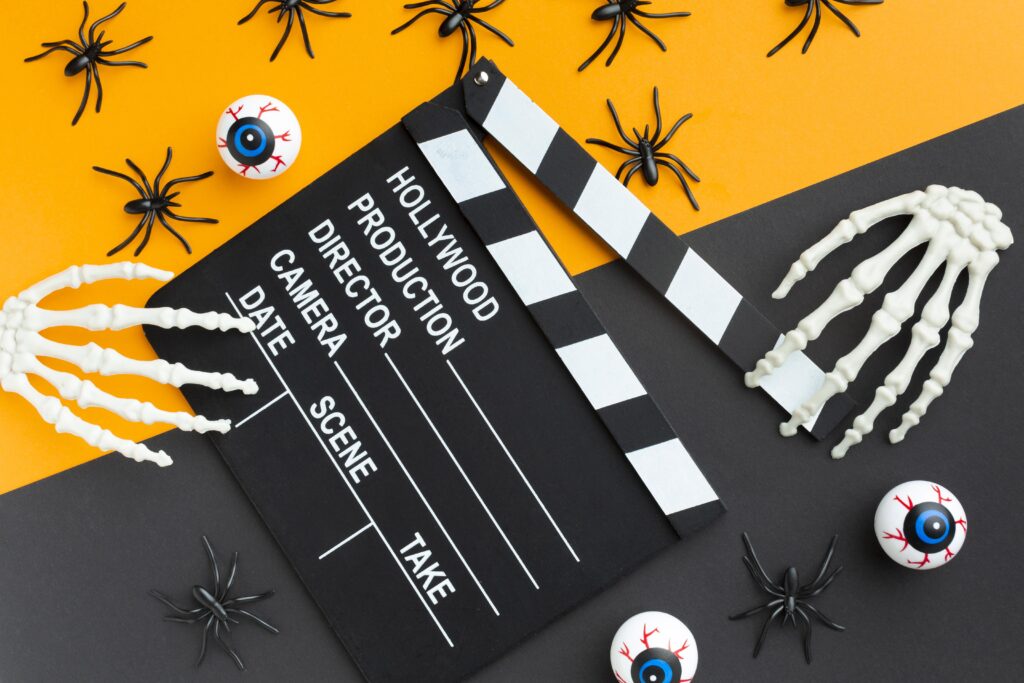 Klapka filmowa otoczona dekoracjami Halloweenowymi.