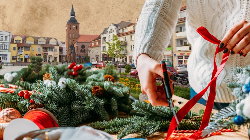 Osoba przycinająca wstążkę na tle miasta.