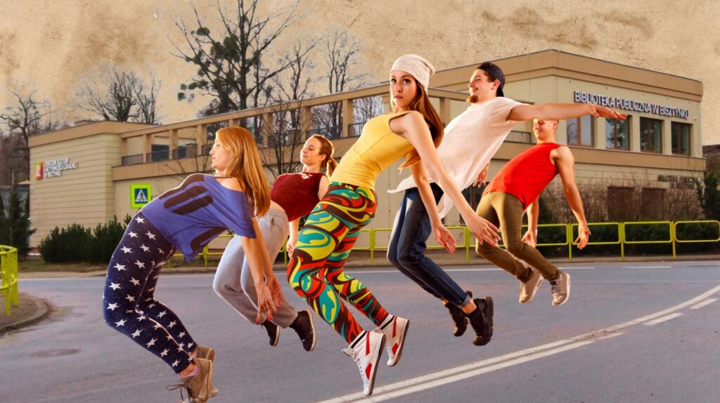 Grupa tańczących osób w powietrzu przy bibliotece.