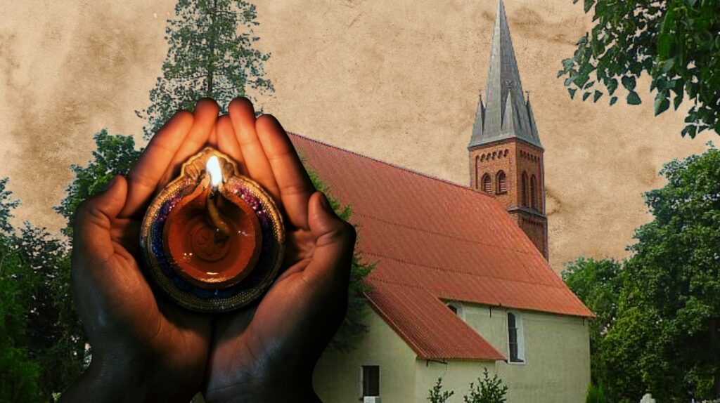 Dłoń trzyma świeczkę przed kościołem.