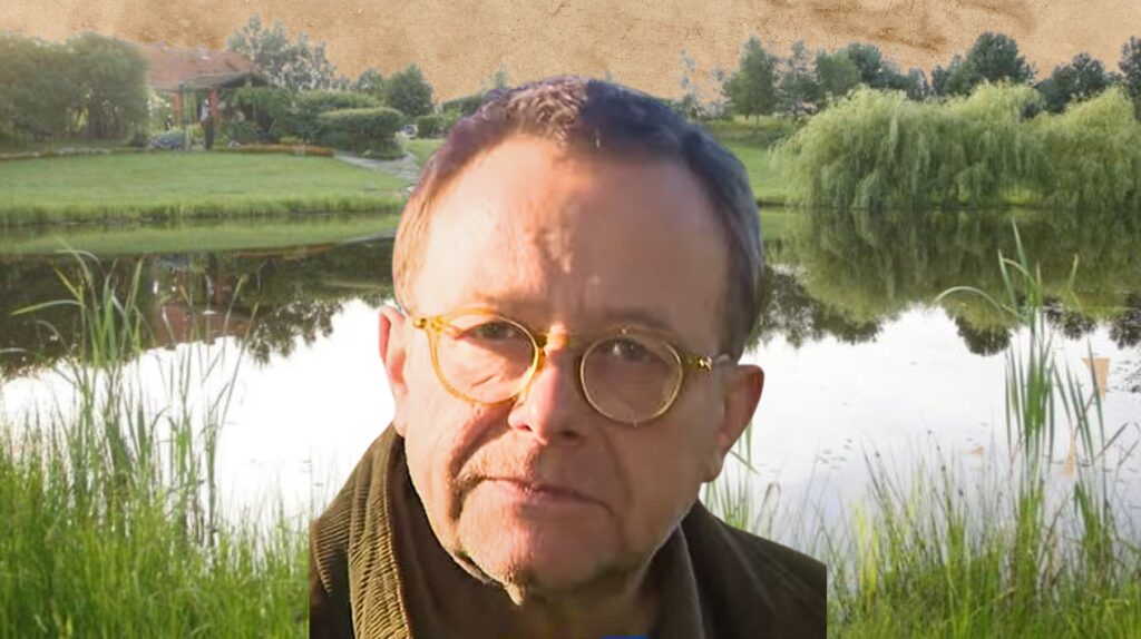 Mężczyzna na tle stawu i zieleni.