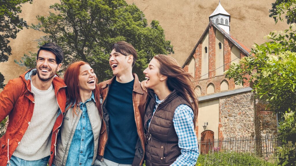 Czwórka przyjaciół uśmiecha się na tle wiejskiego krajobrazu.