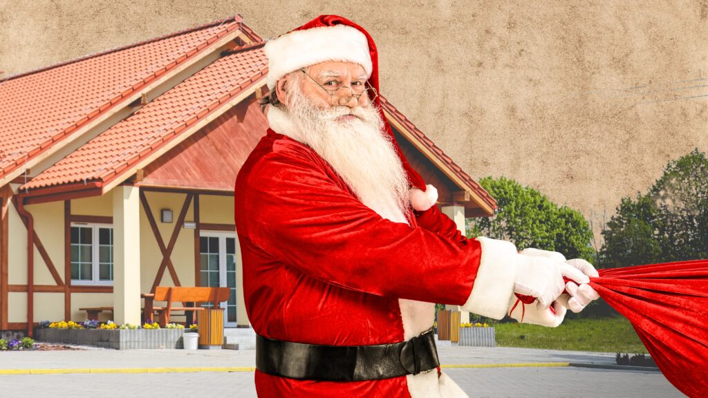 Mężczyzna w stroju Mikołaja trzyma worek.