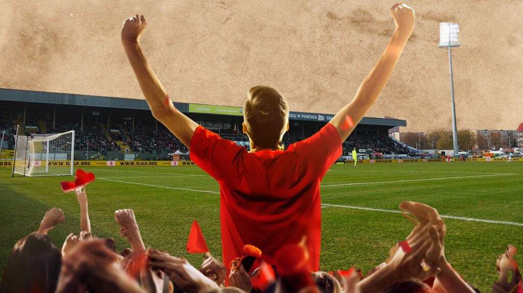 Kibic w czerwonej koszulce cieszy się na stadionie.