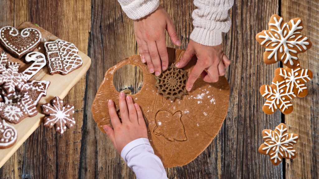 Dwie osoby dekorują ciastka na stole.