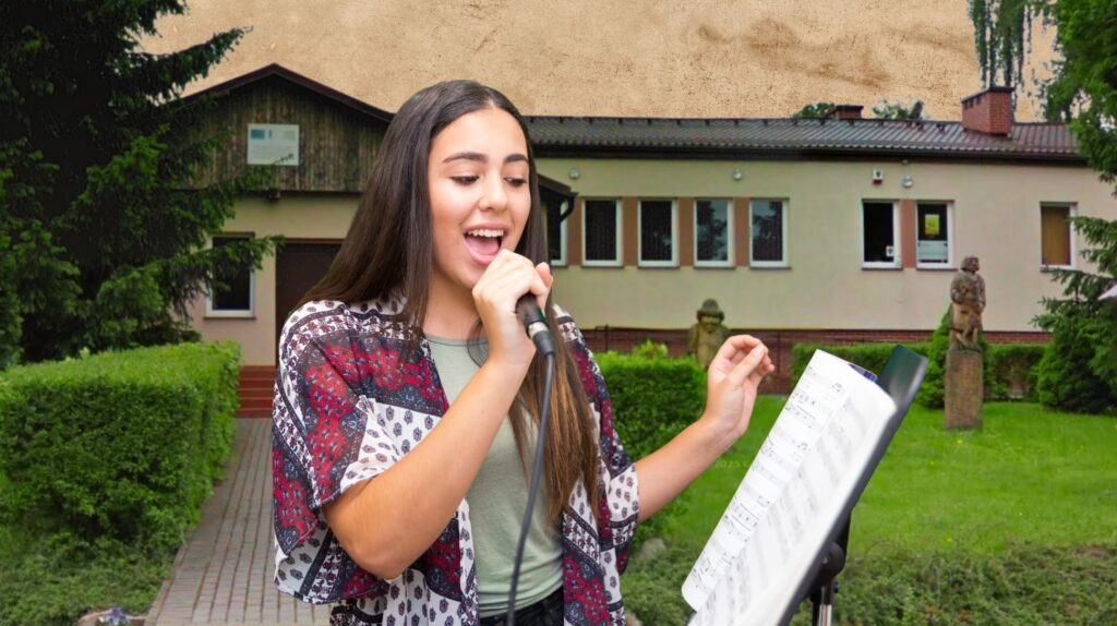 Młoda dziewczyna śpiewająca z mikrofonem na scenie.