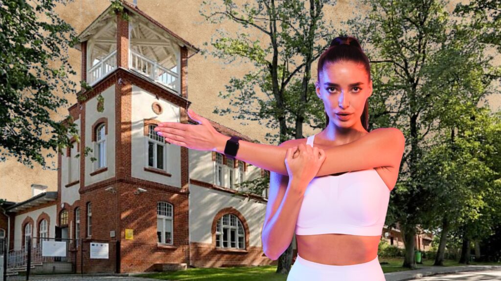 Kobieta w białym stroju przy budynku z czerwonej cegły.