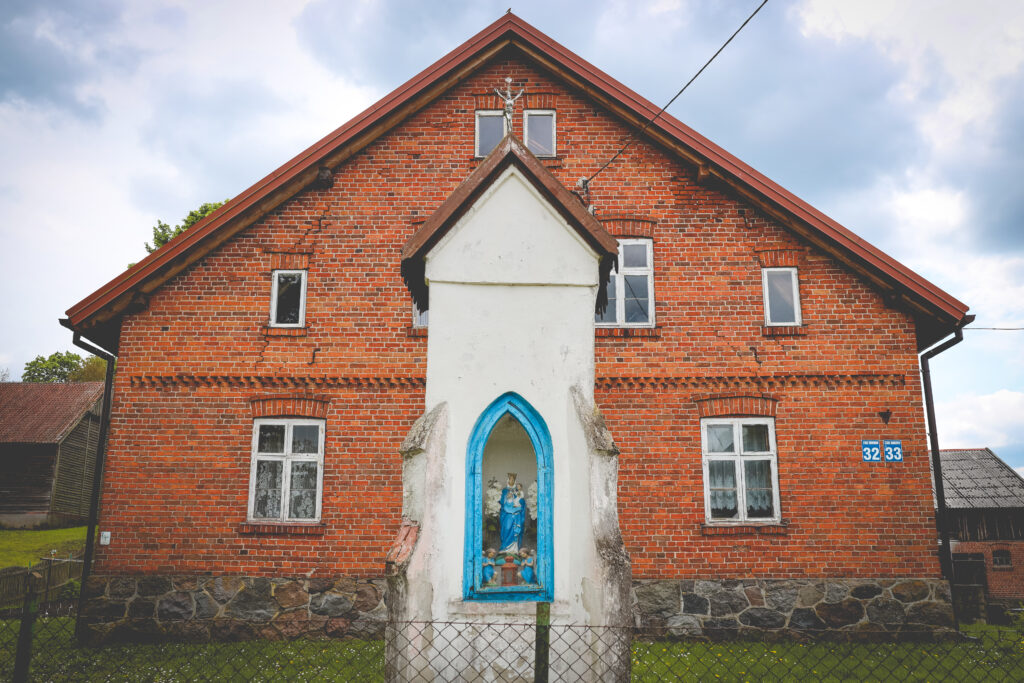 Czerwony dom z figurą w niszy