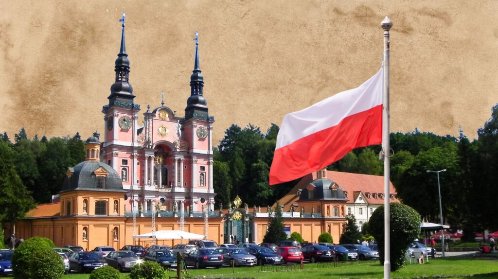 Kościół z widokiem na flagę Polski w tle.