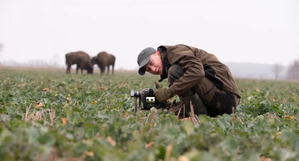 Fotograf wykonujący zdjęcia na polu.