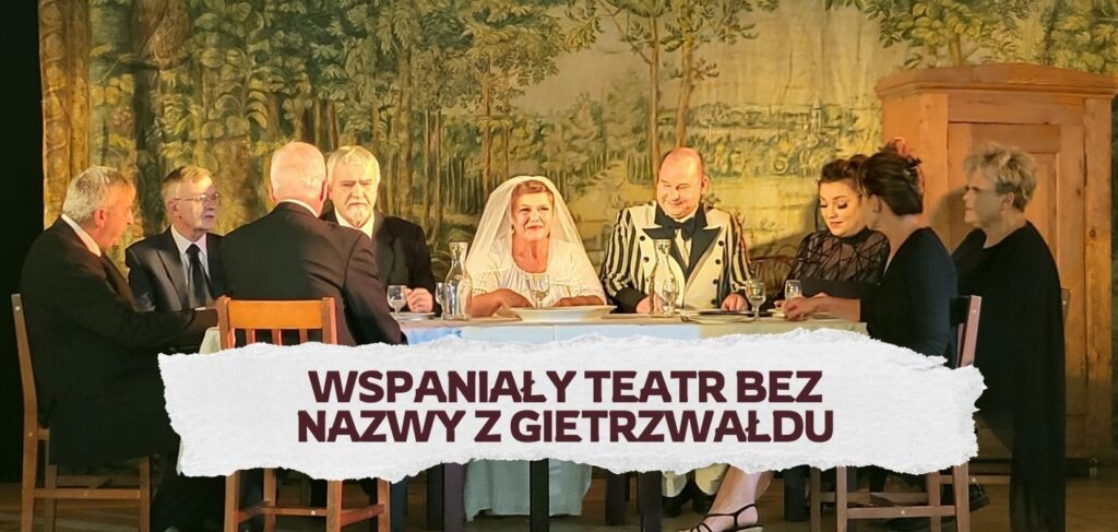 Scena teatralna z aktorami przy stole.
