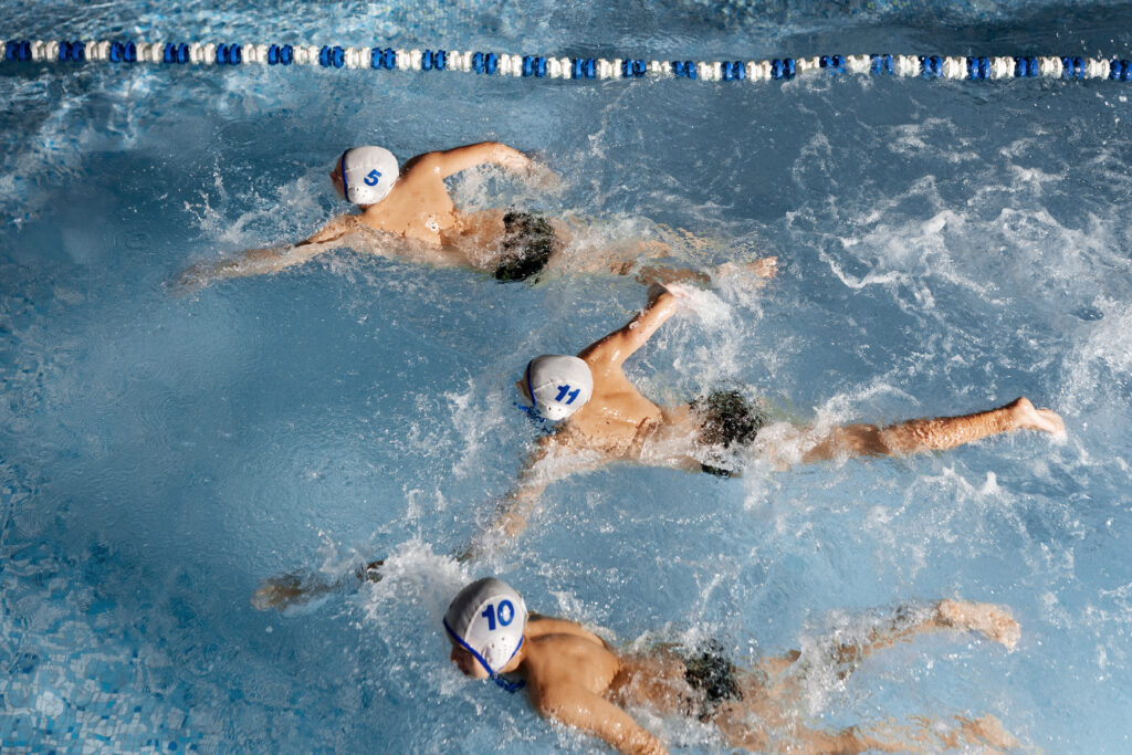 Trzech pływaków w wodzie podczas zawodów.