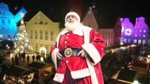 Święty Mikołaj na tle świątecznego jarmarku.